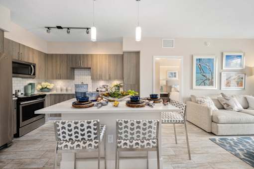 A modern kitchen with a dining table set for two.