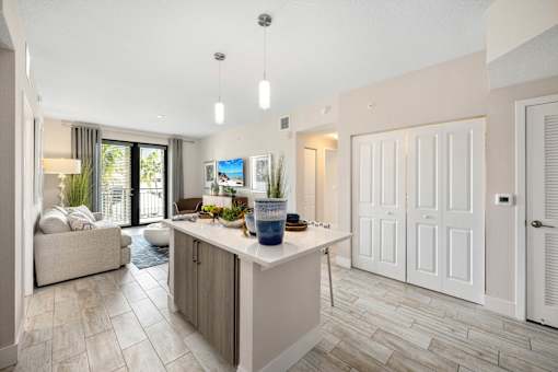 A modern kitchen with a large island and a couch with pillows.
