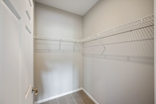 an empty closet with white walls and a white door
