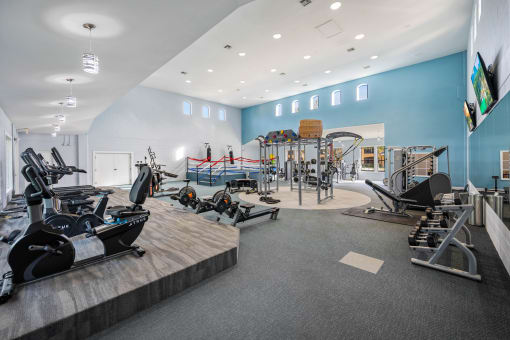 a gym with cardio equipment and weights on a wooden floor
