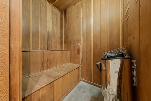 a wood paneled bathroom with a shower and a sink