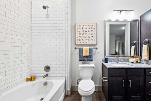 A bathroom with a white tub, toilet, and sink.