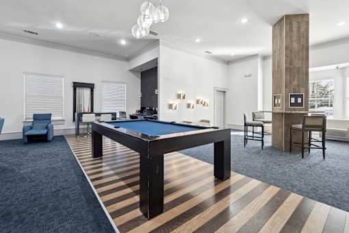 A room with a pool table and a striped carpet.
