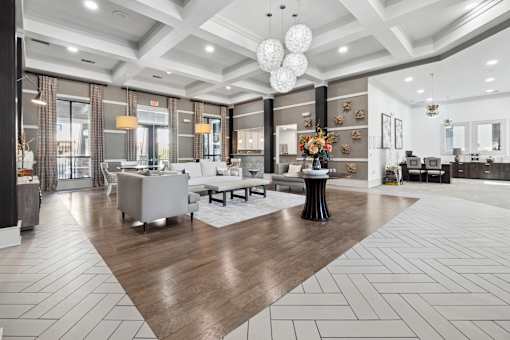 A spacious living room with a wooden floor and white furniture.