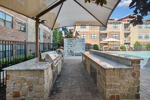 A stone wall with a metal railing and a white umbrella.