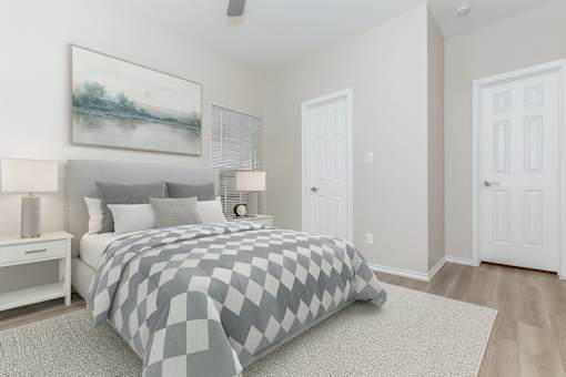 A bedroom with a large bed and a painting on the wall.