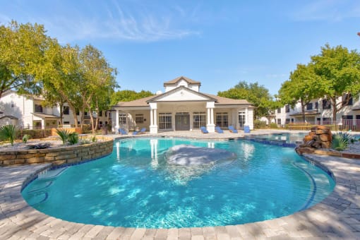 a large pool with a house in the background
