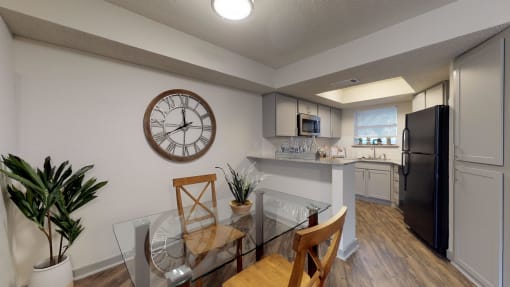 an open kitchen and dining room with a large clock on the wall