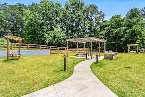a path leading to a park with benches and structures