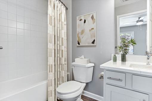 a white bathroom with a shower curtain and a toilet