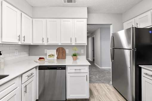 a renovated kitchen with white cabinets and stainless steel appliances