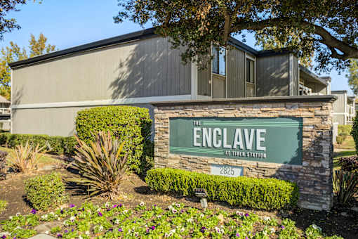 A sign that says "The Enclave at Tiburon Station" in front of a building.
