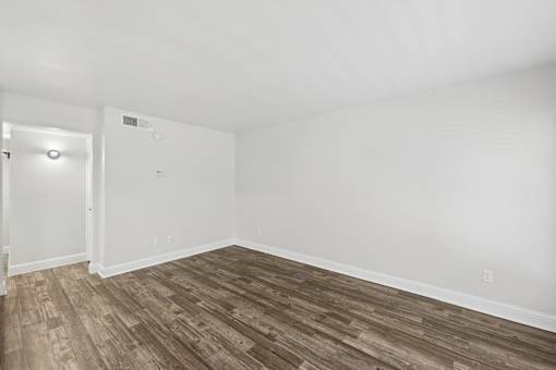 A room with a wooden floor and white walls.