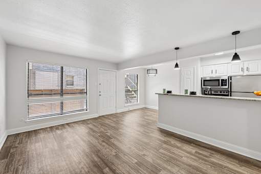 A kitchen with a white counter and wooden floors.