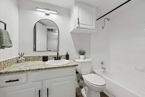A white bathroom with a sink, toilet, and bathtub.