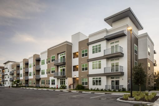 an exterior view of an apartment complex with a parking lot