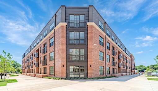 A large red brick building with a lot of windows and balconies.