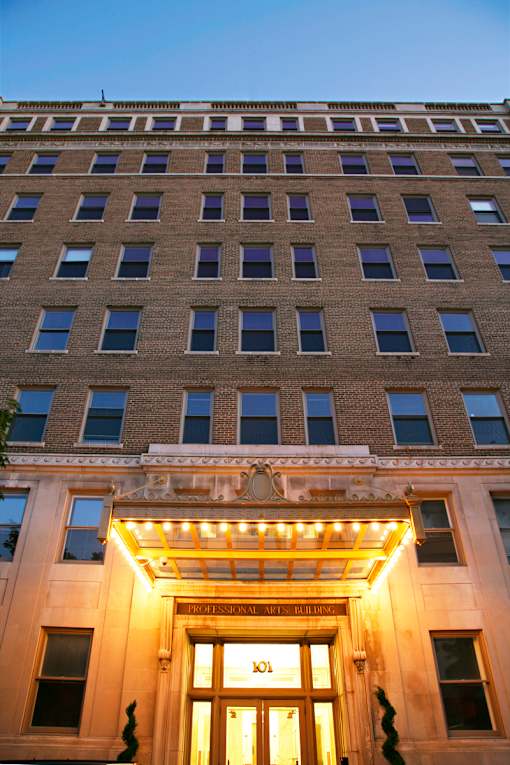 A building with a lit up entrance and a sign that says "Hotel".