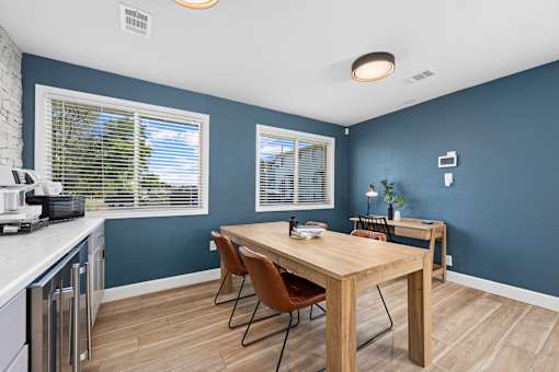 A kitchen with a table and chairs.