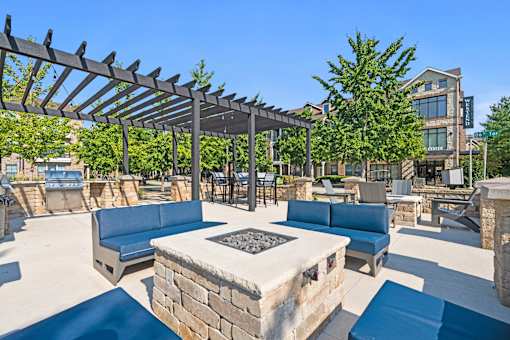 A patio with a fire pit and seating area.