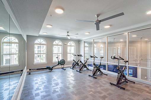 A gym with exercise bikes and a fan.