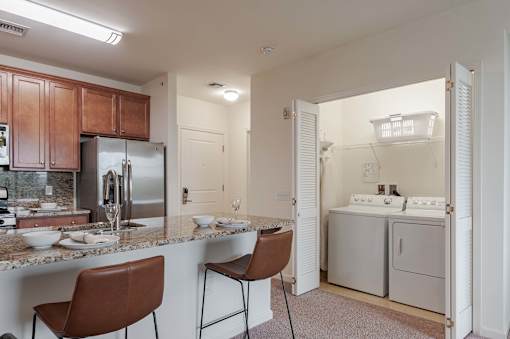 A kitchen with brown chairs and a marble counter top.