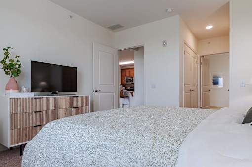 A bedroom with a large bed and a tv on a cabinet.