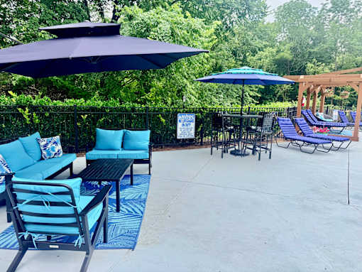 A patio with blue furniture and umbrellas.