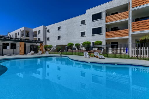 a large swimming pool in front of an apartment building
