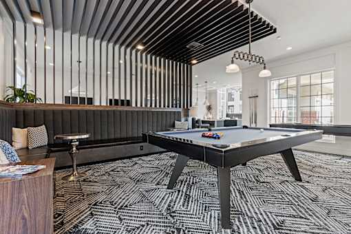 A room with a pool table and a bar.