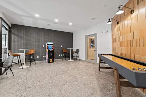 A room with a foosball table and a bar area.