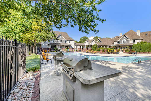 A backyard with a BBQ grill and a pool.