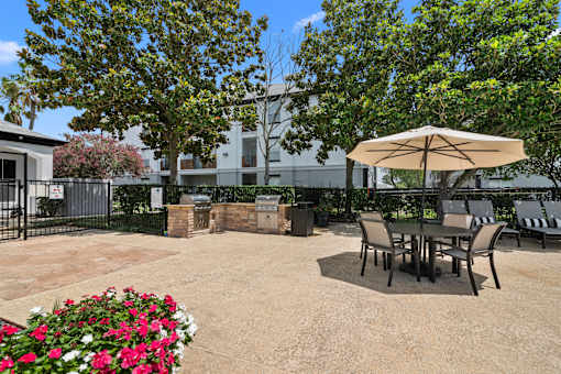 A patio with a table and chairs under an umbrella.
