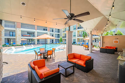 A patio with a pool and furniture.