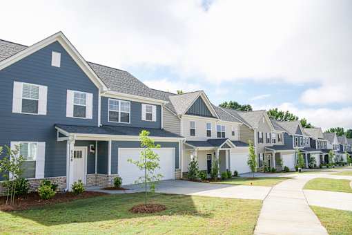 A row of houses with a white garage door in the front.