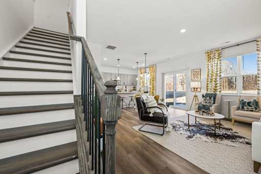 A living room with a staircase on the left side.