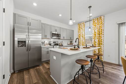 A modern kitchen with a large island and stools.