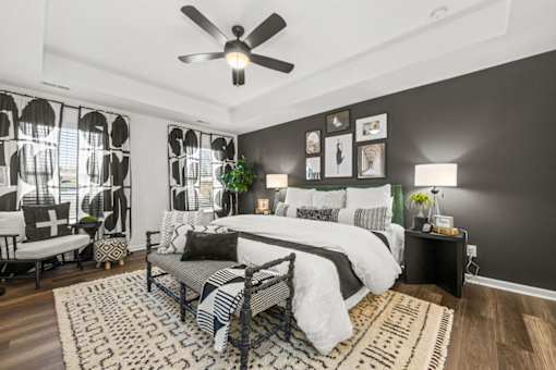 A bedroom with a large bed and a ceiling fan.