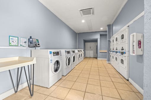 a laundry room with a row of washing machines