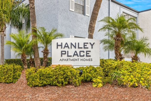 a sign for hanley place apartments in front of palm trees