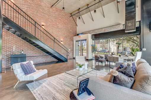 A living room with a grey couch and a glass coffee table.