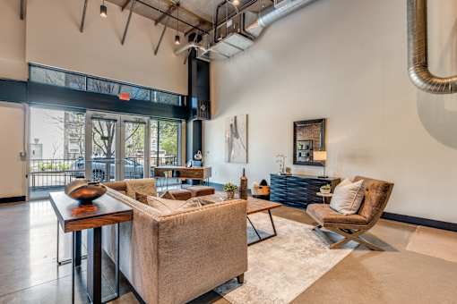 A living room with a couch, chair, and a table with a vase on it.