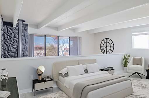 A bedroom with a large bed and a chair.