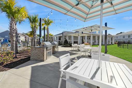 A patio with a table and chairs under a striped umbrella.