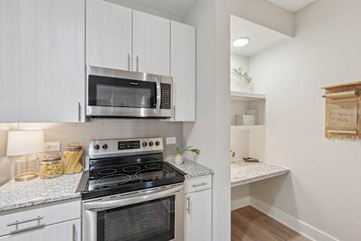 A kitchen with a stove, microwave, and oven.