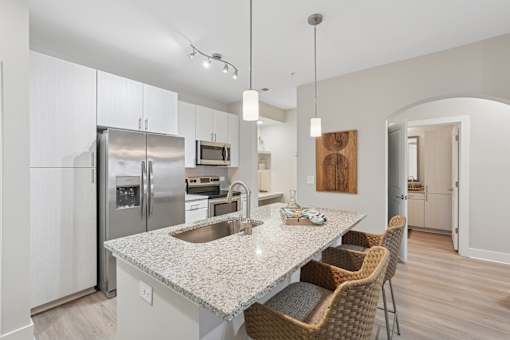 A modern kitchen with a granite countertop and stainless steel appliances.