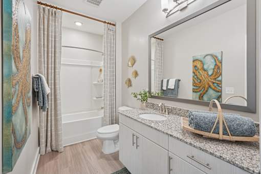 A bathroom with a white toilet, sink, and a mirror.