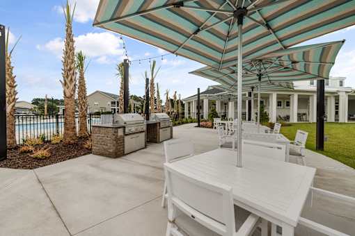 A patio with a table and chairs under a striped umbrella.