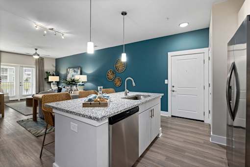 A kitchen with a white island and a stainless steel refrigerator.