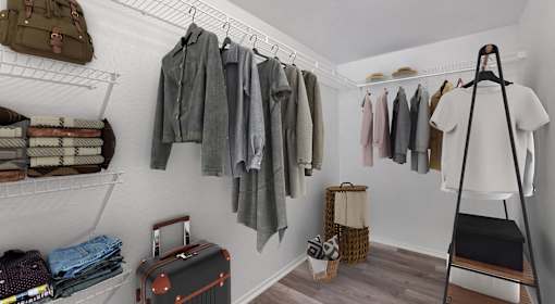 A room with a clothes rack and a suitcase.